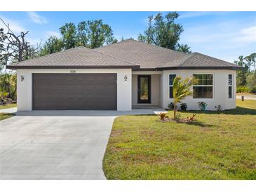 Newly constructed home with a two-car garage and well-manicured lawn at 509 Sunset N Rd, Rotonda West, FL 33947