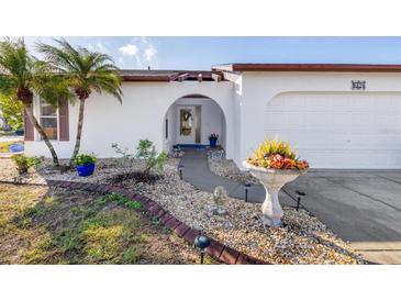 White single-story home with landscaped yard, walkway, and attached garage at 604 Foxwood Blvd, Englewood, FL 34223