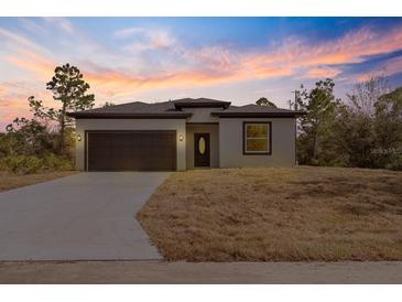 Newly constructed home with a modern exterior and driveway at 158 Chickering St, Port Charlotte, FL 33954