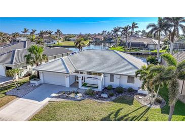 Aerial view of single-story home with tile roof, driveway, and landscaped lawn at 525 Port Bendres Dr, Punta Gorda, FL 33950