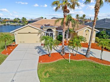 Charming single-story home boasts a lush landscaped front yard and a spacious two-car garage at 1346 Osprey Dr, Punta Gorda, FL 33950