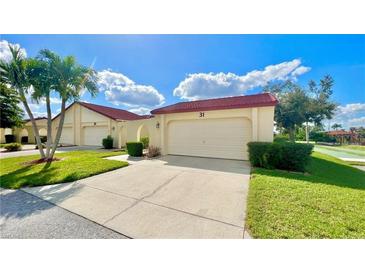 Front view of charming condo with attached garage and well-manicured lawn at 1640 Atares Dr # 31, Punta Gorda, FL 33950