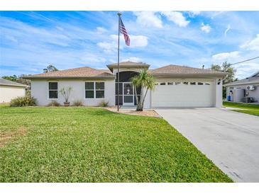 Single-story house with attached garage, manicured lawn, and American flag at 3812 Danbury Ter, North Port, FL 34286