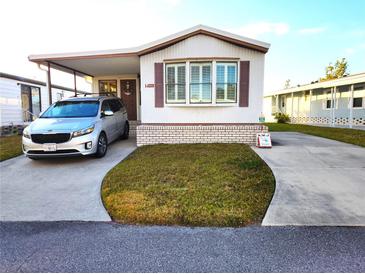 Single-wide manufactured home with carport and small yard at 6501 Center Ln, North Port, FL 34287