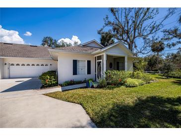 Charming single-story home with a well-manicured front yard and an attached two-car garage at 1407 Red Oak Ln, Port Charlotte, FL 33948