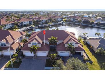 Aerial view of waterfront property showing a luxurious home with private garages and a canal view at 141 Tropicana Dr # 1111, Punta Gorda, FL 33950