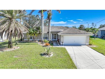 Single-story house with attached garage,palm trees and well-maintained lawn at 20 Medalist Cir, Rotonda West, FL 33947
