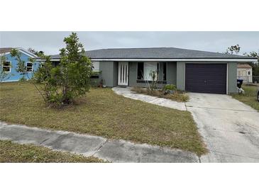 Single-story house with a gray exterior, attached garage, and a small front yard at 2491 Shenandoah St, North Port, FL 34287