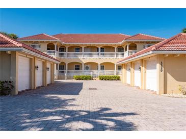 Inviting two-story condo building showcases a red tile roof, white railings, and well-manicured landscaping at 3329 Purple Martin Dr # 113, Punta Gorda, FL 33950