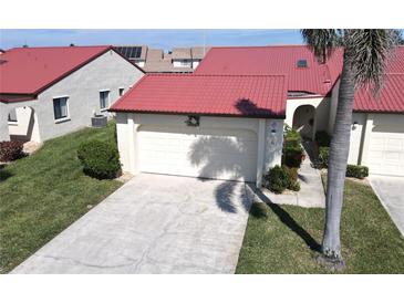 Charming home featuring a well-maintained lawn, two-car garage, and a striking red roof at 3830 Bal Harbor Blvd # 6, Punta Gorda, FL 33950