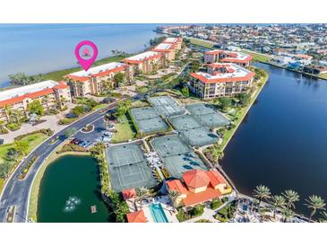 Beautiful aerial view showcasing condos, tennis courts, a pool, and waterfront access in a desirable community at 91 Vivante Blvd # 402/9142, Punta Gorda, FL 33950