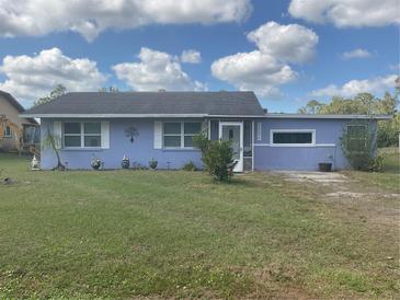 Charming single-story home with light blue exterior, well-maintained lawn and a welcoming front entrance at 12077 Maryland Ave, Punta Gorda, FL 33955