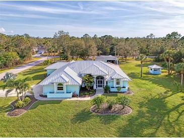 Blue house and landscaping are shown in this property's aerial view at 18181 Bly Ave, Port Charlotte, FL 33948