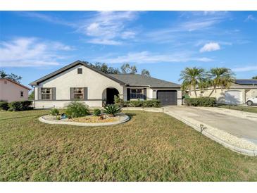 Charming one-story home featuring a well manicured lawn, garden and a driveway leading to a one car garage at 20352 Tappan Zee Dr, Port Charlotte, FL 33952