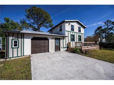 House exterior featuring a two-car garage and a deck at 28094 Chinquapin Dr, Punta Gorda, FL 33955