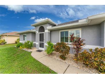 Gray house with landscaped yard and walkway at 3183 Sulstone Dr, Punta Gorda, FL 33983