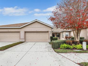 Tan villa with two-car garage and lush landscaping at 4149 Cascade Falls Dr, Sarasota, FL 34243