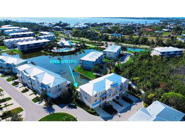 Stunning aerial view of the condo community with waterfront property and well-maintained landscaping near the ocean at 10311 Lands End Cir # 16, Placida, FL 33946