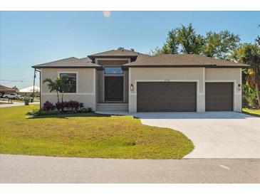 Beautiful single-story home featuring a manicured lawn and a three-car garage at 13356 Rayburn Ln, Port Charlotte, FL 33981