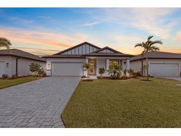 New construction home with paver driveway and landscaped lawn at 1890 Sunset Preserve Way, Port Charlotte, FL 33953