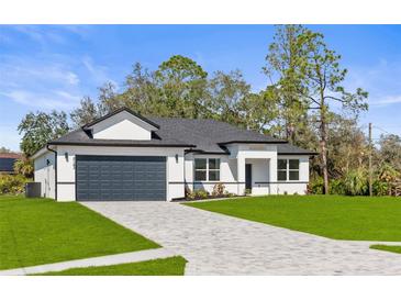 Beautiful, modern single-Gathering home with a well-manicured lawn and a paved driveway leading to a two-car garage at 2143 S Haberland Blvd, North Port, FL 34288