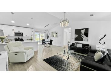 Open-concept living room with modern furniture and large TV at 2325 Hanford Ln, North Port, FL 34288