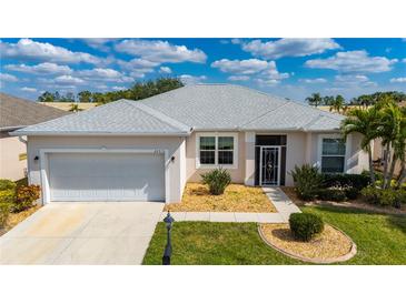 Charming one-story home with a well-maintained lawn, lush landscaping and a two-car garage at 24576 Buckingham Way, Punta Gorda, FL 33980
