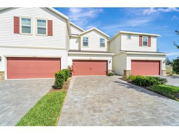 Charming townhouse featuring paver driveway, red garage doors and well manicured landscaping at 11637 Woodleaf Dr # 11637, Bradenton, FL 34211