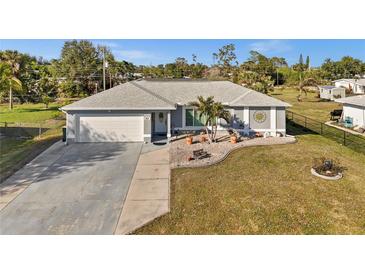 Charming single-story home with a two-car garage, well-maintained lawn, and lovely landscaping at 188 Cypress Nw Ave, Port Charlotte, FL 33952