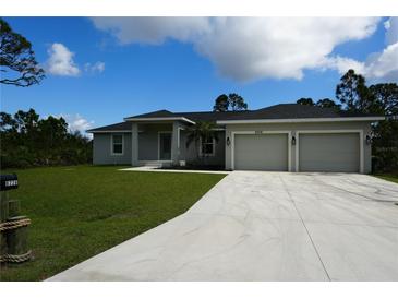 Charming single-story home with a well-manicured lawn, two-car garage, and a modern exterior paint scheme at 8226 Olsen St, Port Charlotte, FL 33981