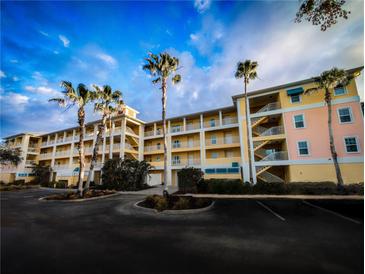 Brightly painted three story condo building with multiple units and external staircases, surrounded by palm trees at 8403 Placida Rd # 408, Placida, FL 33946