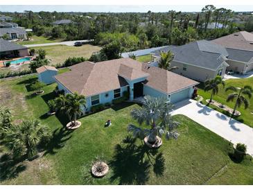 Charming single-story home with a well-manicured lawn, palm trees, and a shed in a desirable neighborhood at 9175 Melody Cir, Port Charlotte, FL 33981