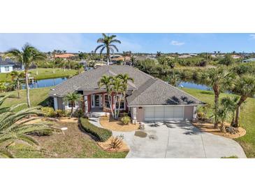 Single Gathering home boasting waterfront views, mature palms and landscaping, and three car garage at 9428 Bandera Ln, Port Charlotte, FL 33981