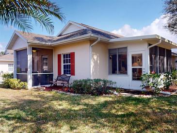 Charming home featuring a screened lanai, manicured lawn, and inviting bench, perfect for outdoor relaxation at 1286 Green Oak Trl, Port Charlotte, FL 33948