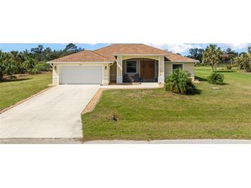 Charming single-story home featuring a well-manicured lawn, attached garage, and neutral-toned exterior at 13157 Ridgely Cir, Port Charlotte, FL 33981