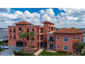 Stunning multi-story building featuring a unique design, a red tile roof and lush tropical landscaping at 1344 Mediterranean Dr # 121, Punta Gorda, FL 33950