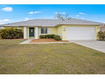 Charming single-story home featuring a two-car garage and well-maintained lawn and mature landscaping at 1364 Ultramarine Ln, Punta Gorda, FL 33983