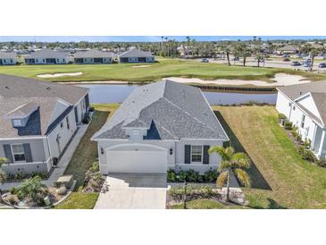 A beautiful home on a manicured lawn is located along the water with a golf course view at 1875 Nottingham Trl, Punta Gorda, FL 33980