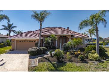 Charming single-story home with a red tile roof, lush landscaping, and a two-car garage at 237 Freeport Ct, Punta Gorda, FL 33950