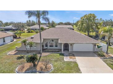 Charming single-story home features a two-car garage, arched windows, mature landscaping and a well maintained lawn at 27566 Tierra Del Fuego Cir, Punta Gorda, FL 33983