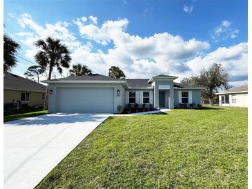 Charming one-story home showcasing a manicured lawn, a two car garage, and a stylish gray color scheme at 2851 Verde Ter, North Port, FL 34286