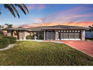 Charming home featuring a well-manicured lawn, lush landscaping, and an inviting front entrance at 295 Porto Alegre St, Punta Gorda, FL 33983