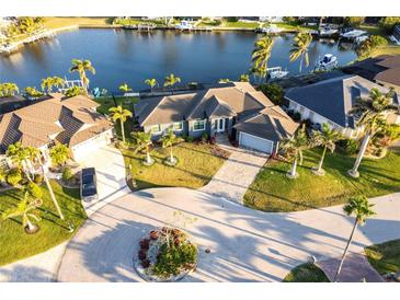 Beautiful waterfront property featuring lush landscaping, a paver driveway and a barrel tile roof at 3612 Licata Ct, Punta Gorda, FL 33950