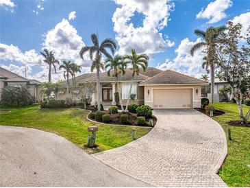 Charming home featuring a tile roof, brick driveway, and beautifully manicured landscaping with palm trees at 1217 Bobwhite Court, Punta Gorda, FL 33950