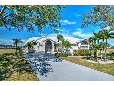 Beautiful home featuring a white metal roof, lush landscaping, and a long private driveway at 24344 Penhollow Ct, Punta Gorda, FL 33955