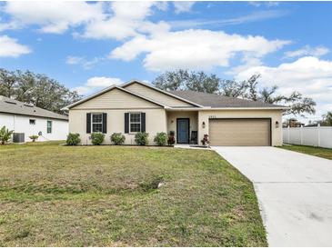 Charming single-story home with beige stucco, dark shutters, well-maintained landscaping, and an attached two-car garage at 2822 Logsdon St, North Port, FL 34287