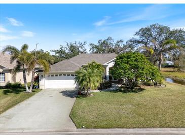 Charming single-story home featuring a two-car garage, lush landscaping, and a well-manicured lawn at 2479 Sonoma Dr W, Nokomis, FL 34275