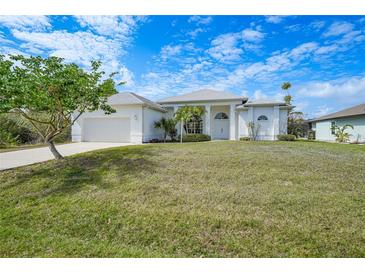 Charming one-story home with a well-manicured lawn and lush landscaping at 3487 Cabaret St, Port Charlotte, FL 33948
