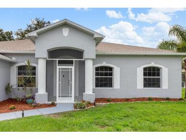 Charming front entrance with beautiful columns, arched window accents, and freshly manicured lawn at 5366 Dunsmuir Rd, North Port, FL 34288