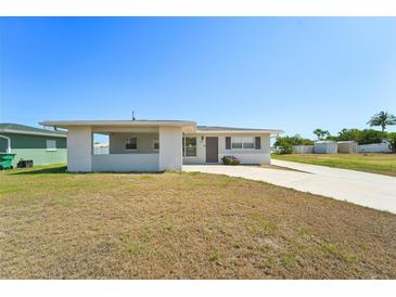 Charming single-story home with a covered entryway and a spacious front yard at 556 Lowell Nw Ave, Port Charlotte, FL 33952
